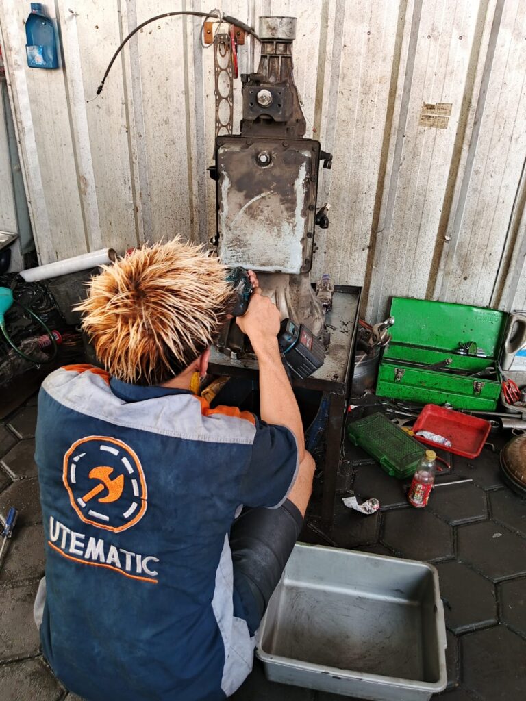 Mekanik spesialis sedang memeriksa komponen transmisi otomatis untuk mendeteksi ciri transmisi mobil matic bermasalah
